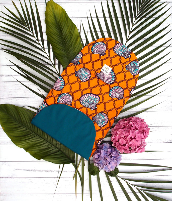 MILIKAI CO 100% cotton bassinet liner handmade from traditional African ankara fabric. Orange sea shell with teal reverse variant. Three layers of inner cotton wadding for extra comfort. Made to complement the MILIKAI CO Pilot stroller. Length 70.5 centimetres, width 32 centimetres.